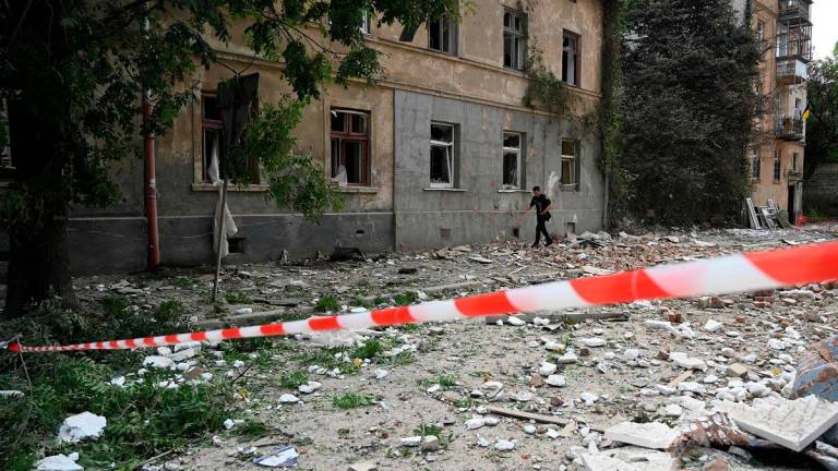 A man walks past a residential building damaged following Russian air attacks in the western Ukrainian city of Lviv on August 21, 2025, amid the Russian invasion of Ukraine. - YURIY DYACHYSHYN / AFP