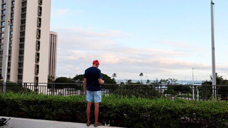 A man stands on a ledge at a shopping center looking for tsunami waves, after authorities warned residents of the possibility of destructive tsunami waves, following an earthquake which earlier struck off Russia’s Far Eastern Kamchatka Peninsula, in Honolulu, Hawaii, U.S. July 29, 2025. - REUTERS/Marco Garcia