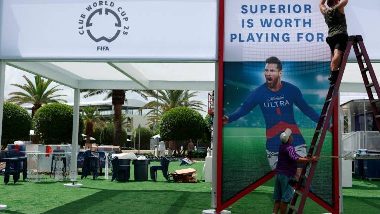 Ground staff puts up a picture of Inter Miami’s Lionel Messi ahead of the Club World Cup REUTERSpix