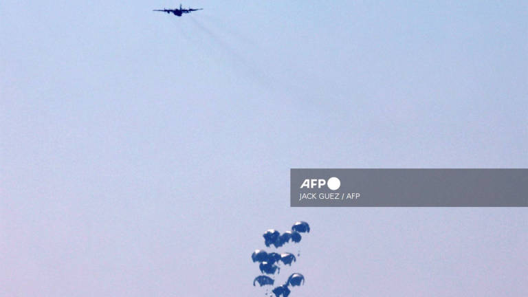 Humanitarian aid is dropped on the Gaza Strip as pictured from a position along the border in southern Israel on July 27, 2025. - AFP