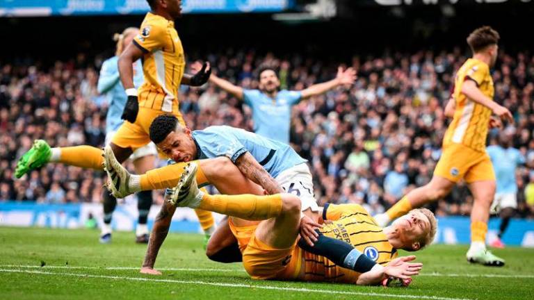 Manchester City's Brazilian midfielder #26 Savinho (up) collides with Brighton's Dutch defender #29 Jan Paul van Hecke as he shoots the ball and misses to score during the English Premier League football match between Manchester City and Brighton and Hove Albion at the Etihad Stadium in Manchester, north west England, on March 15, 2025. - AFPPIX