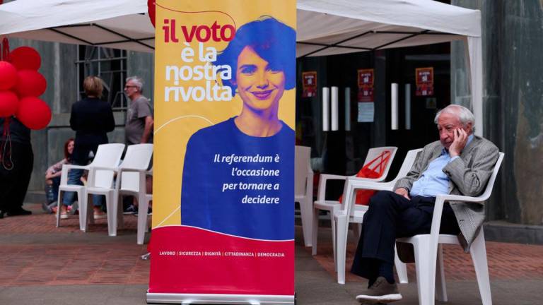 A man sits next to a banner reading 'the vote is our revolt', during a campaign on five abrogative popular referendums regarding employment and Italian citizenship, in Milan, Italy, June 4, 2025. - REUTERSPIX