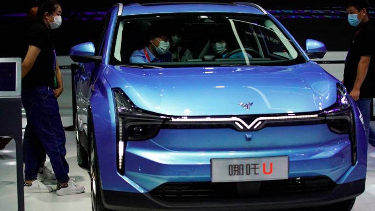 People wearing face masks following the coronavirus disease (COVID-19) outbreak are seen inside a Neta U car by Hozon at the Beijing International Automotive Exhibition, or Auto China show, in Beijing, China September 27, 2020. - REUTERS