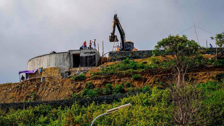 This picture taken on September 24, 2025 shows construction crew working on a hilltop, land which once belonged to villagers before it was taken over by the government to build the country’s MotoGP racing circuit, in Indonesia’s Lombok island, West Nusa Tenggara. - Jack Moore / AFP