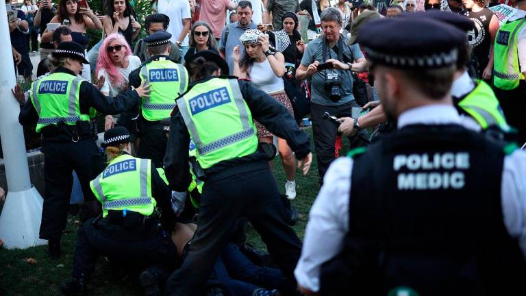 A protester is arrested by police officers at a Lift The Ban demonstration in support of the proscribed group Palestine Action, calling for the recently imposed ban to be lifted, in Parliament Square, central London, on August 9, 2025. Organisers expect at least 500 people to turn up to a new demonstration in support of Palestine Action today, and police have warned all demonstrators could face arrest. Palestine Action was proscribed under the 2000 Terrorism Act. - HENRY NICHOLLS / AFP
