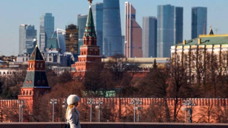 FILepix: A woman walks along a bridge, with the Moscow City business centre and the Kremlin wall seen in the background, on a sunny day in Moscow, Russia, February 24, 2025. REUTERSpix,