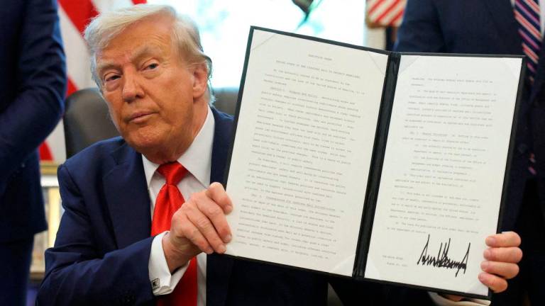 U.S. President Donald Trump holds up an executive order after signing it in the Oval Office at the White House in Washington, D.C. Reuterspix/TPX IMAGES OF THE DAY
