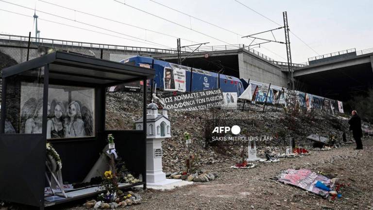 A man pays respect to the victims at the crash site to mark two years since the “national trauma” of the train crash on 28 February 2023 which killed 57 people, mostly students, and injured dozens, in the valley of Tempi, near Larissa, on February 27, 2025. (Photo by Sakis Mitrolidis / AFP)