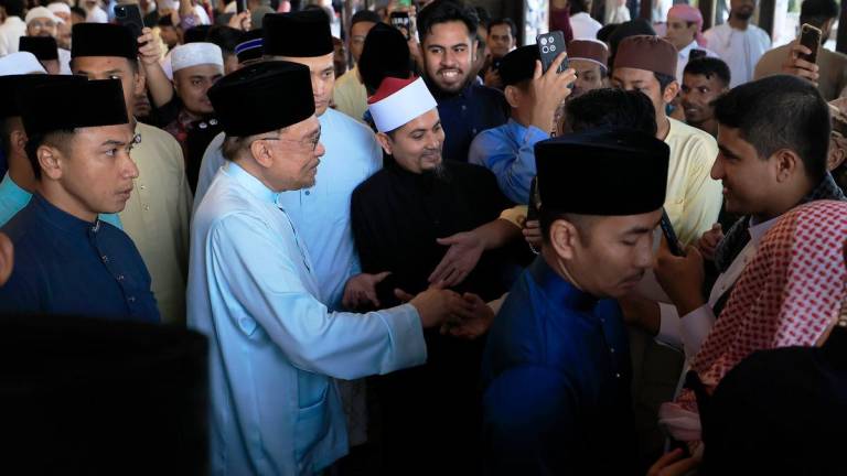 Perdana Menteri Datuk Seri Anwar Ibrahim bersalaman bersama orang ramai selepas hadir menunaikan solat sunat Aidiladha di Masjid Putra hari ini. fotoBERNAMA