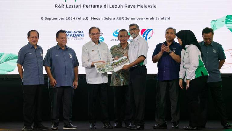 Perdana Menteri Datuk Seri Anwar Ibrahim menunjukkan buku yang memaparkan Kawasan Rehat &amp; Rawat Seremban (Arah Selatan) : R&amp;R Lestari Pertama pada majlis perasmiannya hari ini. - fotoBERNAMA