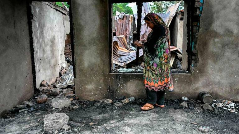 A woman stands outside her house destroyed by Pakistani artillery shelling at the Salamabad village in Uri, about 110kms from Srinagar, on May 8, 2025.AFPpix