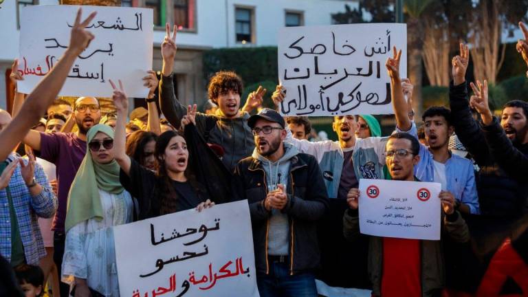People take part in a youth-led demonstration demanding reforms to public healthcare and education in front of the parliament in Rabat on October 18, 2025. - Abdel Majid BZIOUAT / AFP