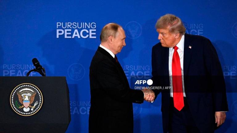 US President Donald Trump and Russian President Vladimir Putin shake hands at the end of a joint press conference after participating in a US-Russia summit on Ukraine at Joint Base Elmendorf-Richardson in Anchorage, Alaska, on August 15, 2025. - Drew ANGERER / AFP