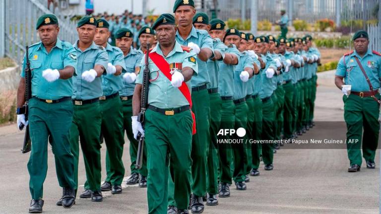 A handout photo released by the Government of Papua New Guinea on September 14, 2025 shows soldiers marching for a guard of honour ceremony at Port Moresby International Airport. A defence deal to be signed this week could see Papua New Guineans serve in the Australian military, Canberra’s defence minister said on September 15, in a pact seen as aimed at countering Beijing’s rising influence in the Pacific.