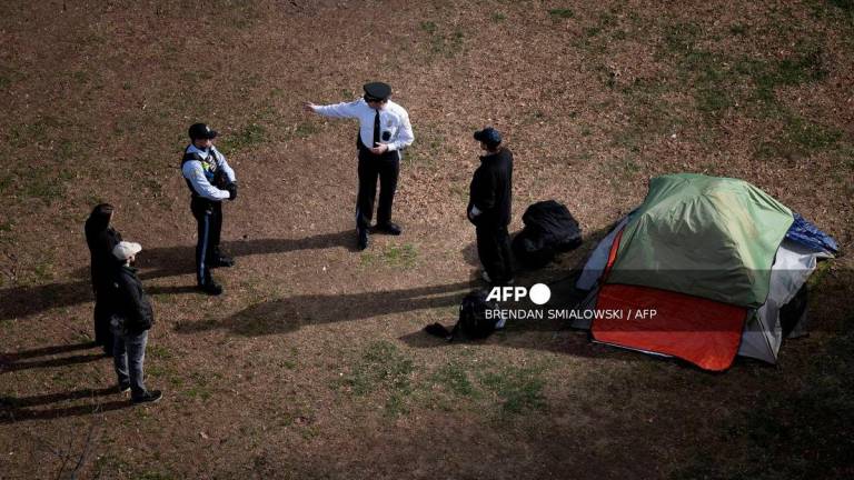 Park Police talk to a man who refused to leave after members of the US National Park Service cleared a homeless encampment from McPherson Square, two blocks from the White House in Washington, DC, on February 15, 2023. (Photo by Brendan Smialowski / AFP)