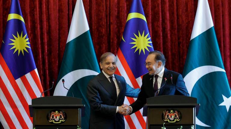 Prime Minister Datuk Seri Anwar Ibrahim shakes hands with Pakistan Prime Minister Muhammad Shehbaz Sharif (left) after a joint press conference at the Perdana Putra Building today. - BERNAMA