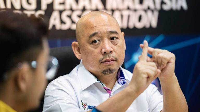 Presiden Persatuan Sukan Orang Pekak Malaysia (MSDeaf), Dr Ong Shin Ruenn, berkomunikasi menggunakan bahasa isyarat pada sidang media berkaitan pengumuman Belanjawan 2026 di Pejabat MSDeaf, hari ini. - BERNAMA