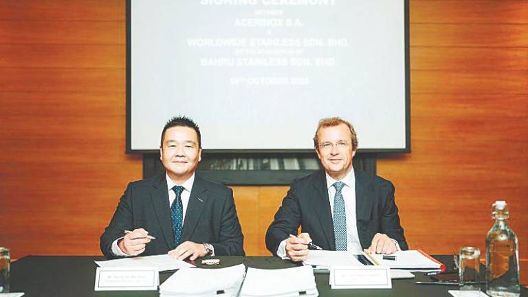 Tan (left) and Acerinox S.A. general counsel &amp; board secretary Luis Gimeno at the signing ceremony.