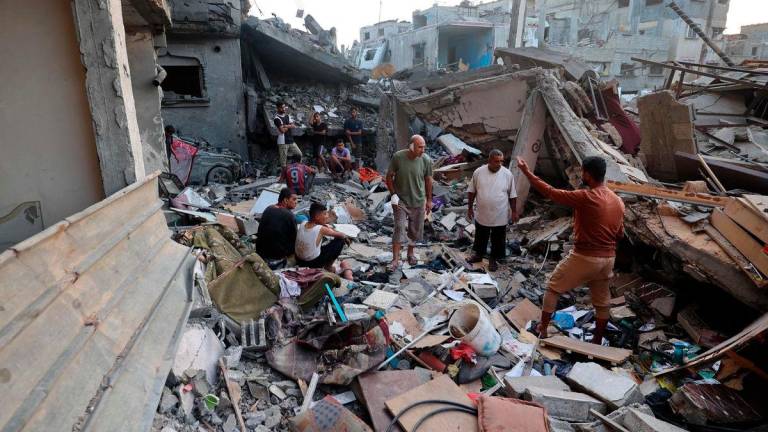 Palestinians check the rubble of a building destroyed by an Israeli strike in the Nuseirat refugee camp in the central Gaza Strip on September 28, 2025. (Photo by Eyad BABA / AFP)