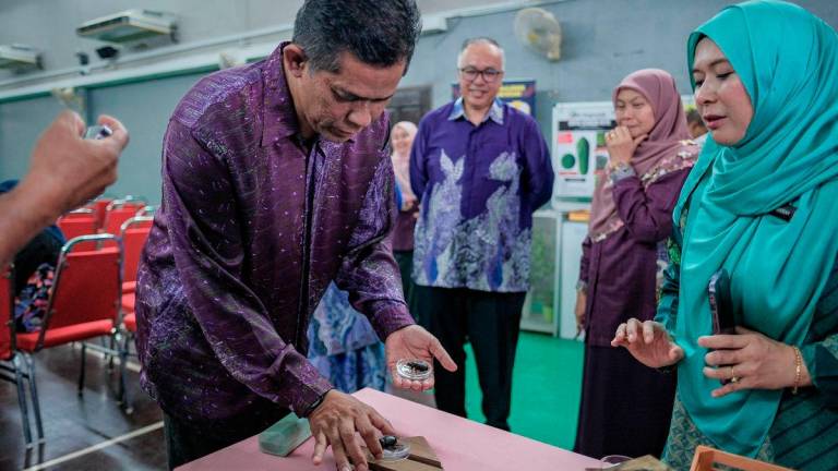 Timbalan Ketua Pengarah Pertanian (Pengurusan dan Regulator) Mat Iesak Ngathinee (kiri) melihat kumbang tanduk pada Majlis Perasmian Penutup Seminar Ancaman Spesies Asing Invasif terhadap Tanaman Kelapa dan Kelapa Sawit di Pusat Pertanian Ayer Hitam, hari ini. - BERNAMA