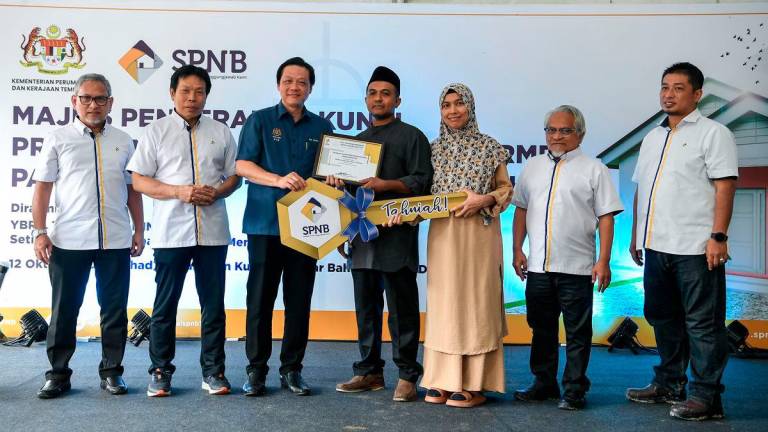 The Political Secretary to the Prime Minister, Chan Ming Kai, handed over a mock key to some recipients of the Rumah Mesra Rakyat (People’s Friendly Homes) at the Key Handover Ceremony for Rumah Mesra Rakyat in Kedah state, held at Kampung Badlishah today. Also present was the Chairman of Syarikat Perumahan Negara Berhad (SPNB), Datuk Prof Dr Mohd Azmi Mohd Lila (second from left). - BERNAMA