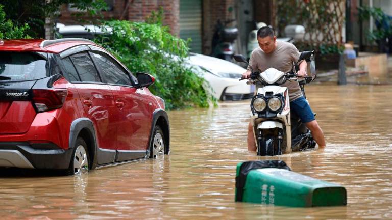 A man rides through a flooded street in Zhongshan, in China’s southern Guangdong province on June 17, 2025. China OUT (Photo by AFP)