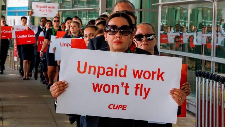FILE PHOTO: Air Canada flight attendants, represented by the Canadian Union of Public Employees (CUPE) hold a picket at one of four airports to highlight their pay demands in contract negotiations with Canada’s largest airline, outside Toronto Pearson International Airport in Mississauga, Ontario, Canada August 11, 2025. REUTERS/Carlos Osorio/File Photo