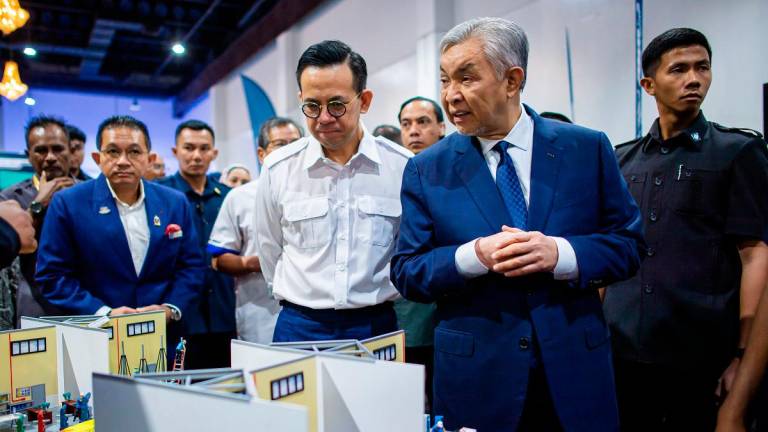 Ahmad Zahid and Sim visit an exhibition after the conference yesterday. – BERNAMApix