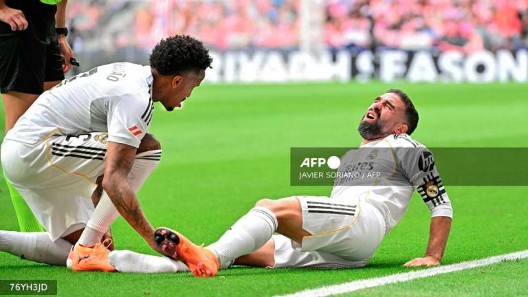 Real Madrid's Spanish defender #02 Dani Carvajal reacts on the ground during the Spanish league football match between Club Atletico de Madrid and Real Madrid CF at the Metropolitano stadium in Madrid on September 27, 2025. - AFP
