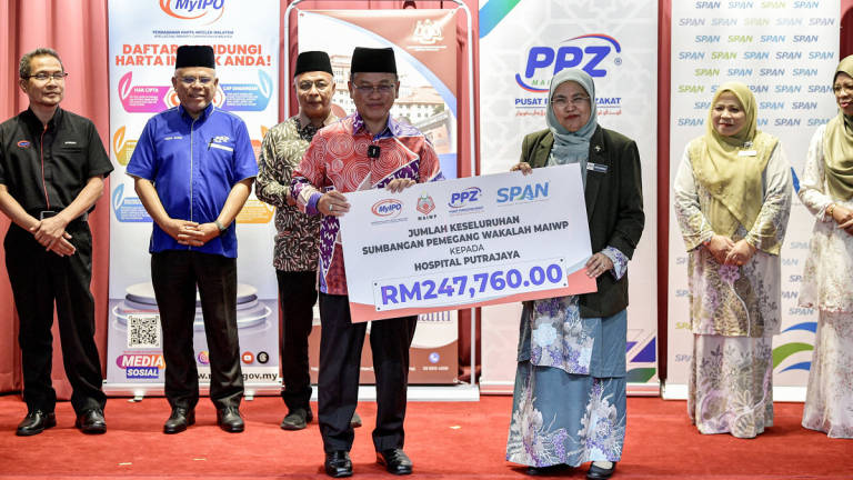 Minister in the Prime Minister’s Department (Religious Affairs), Datuk Dr Mohd Na’im Mokhtar, presenting a mock cheque representing the total contribution from MAIWP Wakalah holders to the State Health Director, Federal Territories Health Department of Kuala Lumpur and Putrajaya, Dr Nor’aishah Abu Bakar, at the Symbolic Handover Ceremony of Wakalah Funds for the Purchase of Equipment for Putrajaya Hospital, here today. – BERNAMA