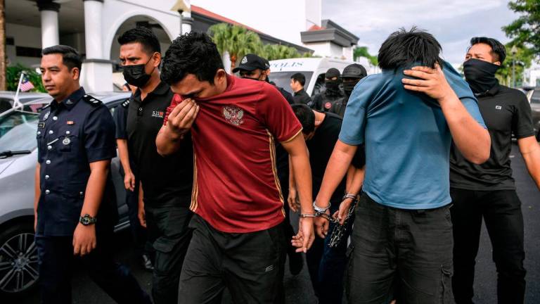 Four men were brought before the Magistrates’ Court here today on a charge of murdering a police officer earlier this month. – BERNAMA