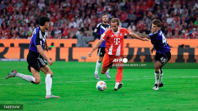 Bayern Munich's English forward #09 Harry Kane (C) kicks to score the 5-0 goal during the German first division Bundesliga football match between FC Bayern Munich and HSV Hamburg in Munich, southern Germany, on September 13, 2025. - AFP