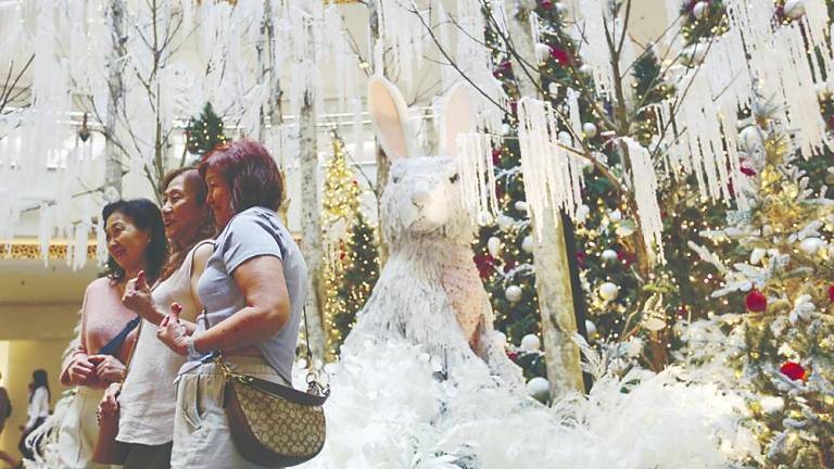 PHOTO WORTHY ... Visitors taking pictures of the Christmas decorations at Mid Valley Megamall in Kuala Lumpur yesterday – ADAM AMIR HAMZAH/THESUN