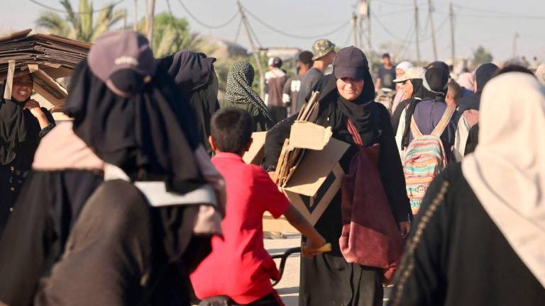Palestinians make their way in the Mawasi area of Rafah on July 24, 2025, after receiving humanitarian aid from an aid distribution point in the southern Gaza Strip. (Photo by AFP)