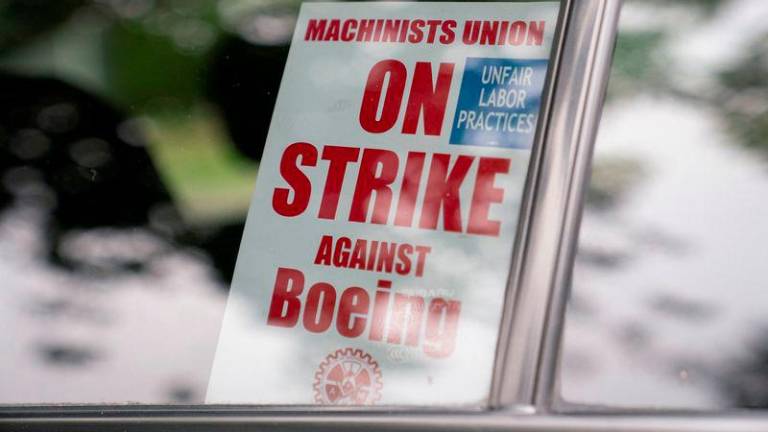 A strike sign is seen in a Boeing worker's car as union members from the International Association of Machinists and Aerospace Workers District 751 arrive to vote on a new contract proposal at a union hall during an ongoing strike in Renton, Washington, U.S. October 23, 2024. - REUTERSPIX