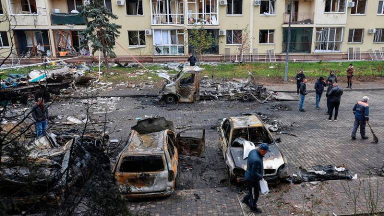 Residents gather next to their destroyed cars and a damaged apartment building hit by a Russian drone strike, amid Russia’s attack on Ukraine - REUTERSpix