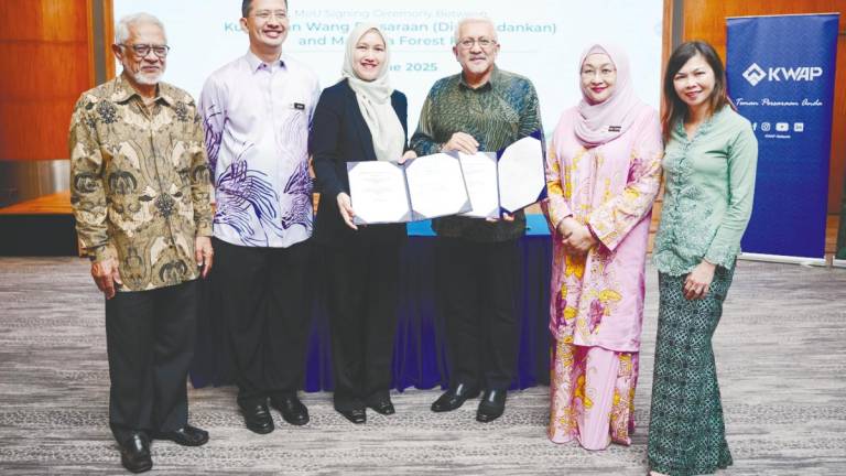 Nik Amlizan and Shah Redza posing with the MoU documents.