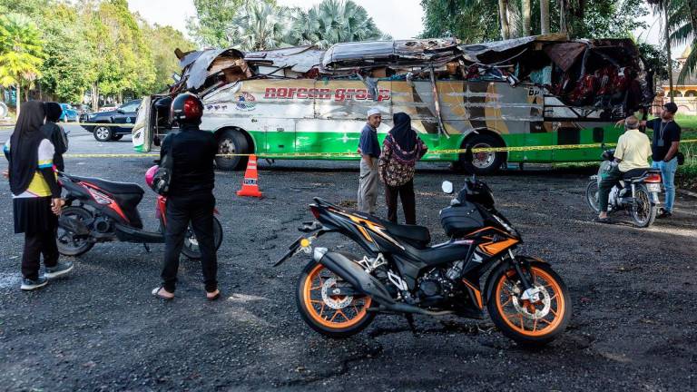 People looking at the condition of the bus involved in the horrific accident that claimed the lives of 15 individuals, early yesterday morning in front of the Gerik district police headquarters today. - Bernama pic