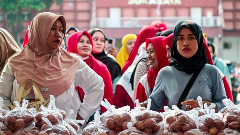 People queue to buy eggs, and other basic necessities at a market in Surabaya on September 23, 2025. - AFPPIX