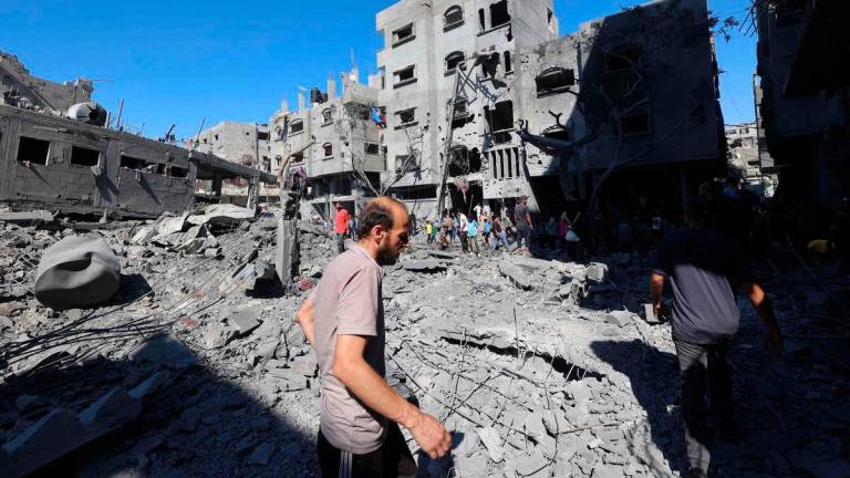 Palestinians inspect the damage after an Israeli strike in the Al-Bureij camp in the central Gaza Strip on July 4, 2025. (Photo by Eyad BABA / AFP)
