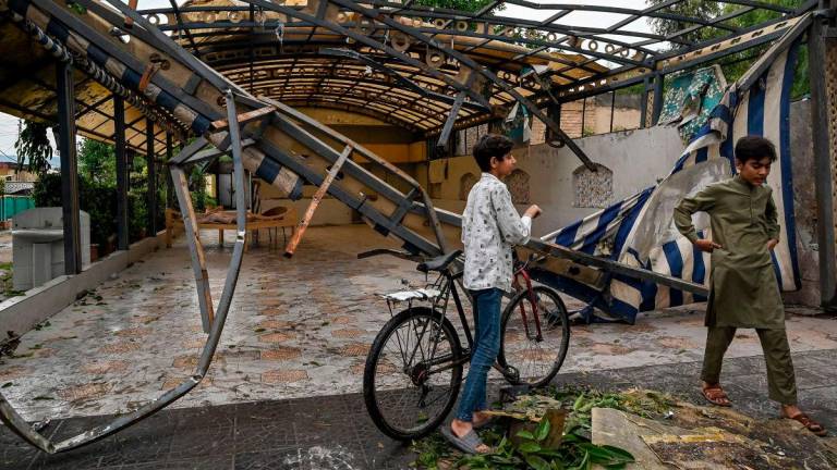 Youths gather in front of the wreckage of a restaurant’s shade outside the Rawalpindi cricket stadium after an alleged drone was shot down in Rawalpindi on May 8, 2025. AFPpix