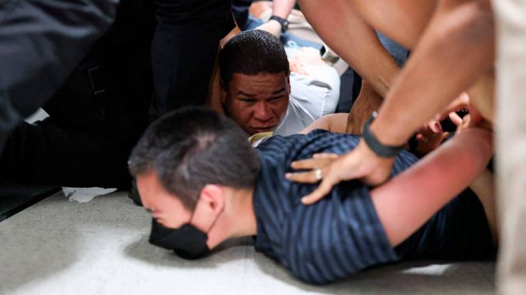 Joaquin Rosario (in white shirt), 34, from the Dominican Republic, is detained by plainclothes officers with Immigration and Customs Enforcement (ICE) after his court hearing in a hallway outside of a courtroom at New York-Federal Plaza Immigration Court inside the Jacob K. Javitz Federal Building in New York City on June 6, 2025. - AFPPIX
