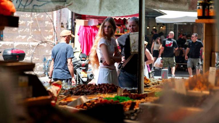 People walk past and observe market stalls selling Middle Eastern produce, in Tel Aviv, Israel, June 27, 2025. - REUTERSPIX
