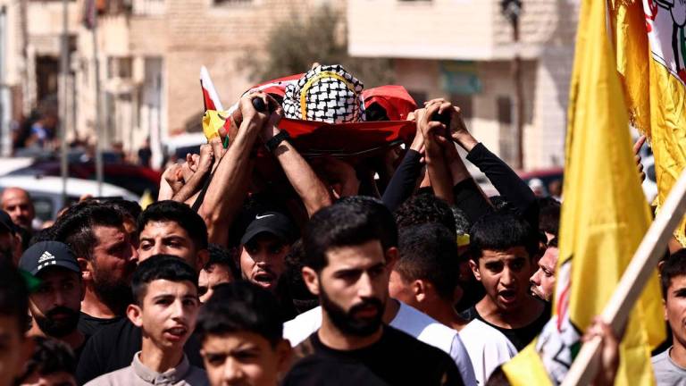 Mourners carry the body of 20-year-old Said Al-Naasan, who was killed during clashes with Israeli settlers the previous day, during his funeral in the occupied West Bank village of Al-Mughayyir, north of Ramallah on September 24, 2025. (Photo by Zain JAAFAR / AFP)