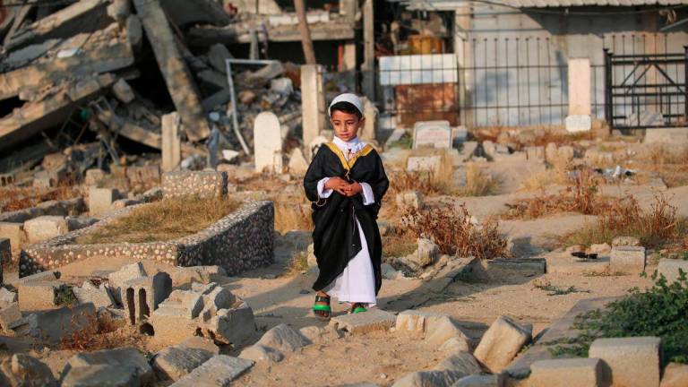 A Palestinian child visits the grave of a loved one on the first day of the Muslim Eid al-Adha festival in Nuseirat, in the central Gaza Strip, on June 6, 2025, amid the ongoing war between Israel and Hamas. - AFPPIX