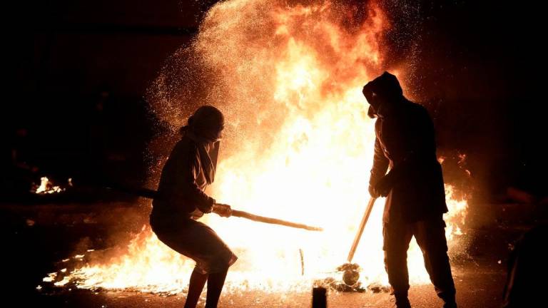 Demonstrators stand next to fire burning during a protest against rising crime, economic insecurity, and corruption, a day after President Jose Jeri presented his cabinet, in Lima, Peru, October 15, 2025. - REUTERSPIX