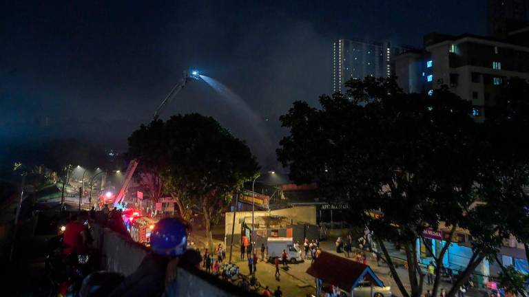 Anggota Jabatan Bomba dan Penyelamat Malaysia (JBPM) giat memadamkan sisa kebakaran yang menyebabkan beberapa buah lot kedai dan rumah di Pantai Dalam, Kuala Lumpur terbakar dalam kejadian malam tadi. - fotoBERNAMA