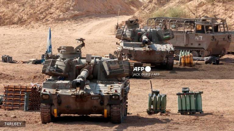 This picture taken from a position at Israel's border with the Gaza Strip shows Israeli mobile artillery units deployed near the border fence with the besieged Palestinian territory on September 17, 2025. - AFP