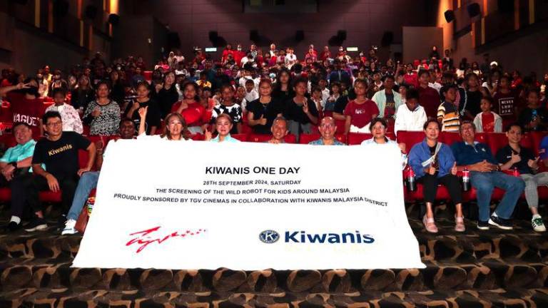 Mr Tan Lay Han, Chief Executive Officer of TGV Cinemas and Kiwanis Malaysia Governor Michael Chiew (seated middle) flanked by Kiwanis leaders and kids before the opening of the movie.