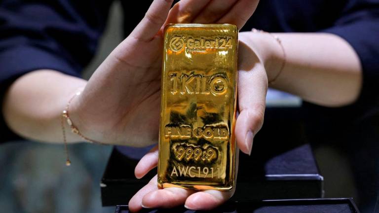 FILE PHOTO: A staff member shows a one-kilogram gold bar at the Galeri 24 gold and jewellery shop in Jakarta, Indonesia, October 9, 2025. REUTERS/Ajeng Dinar Ulfiana/File Photo